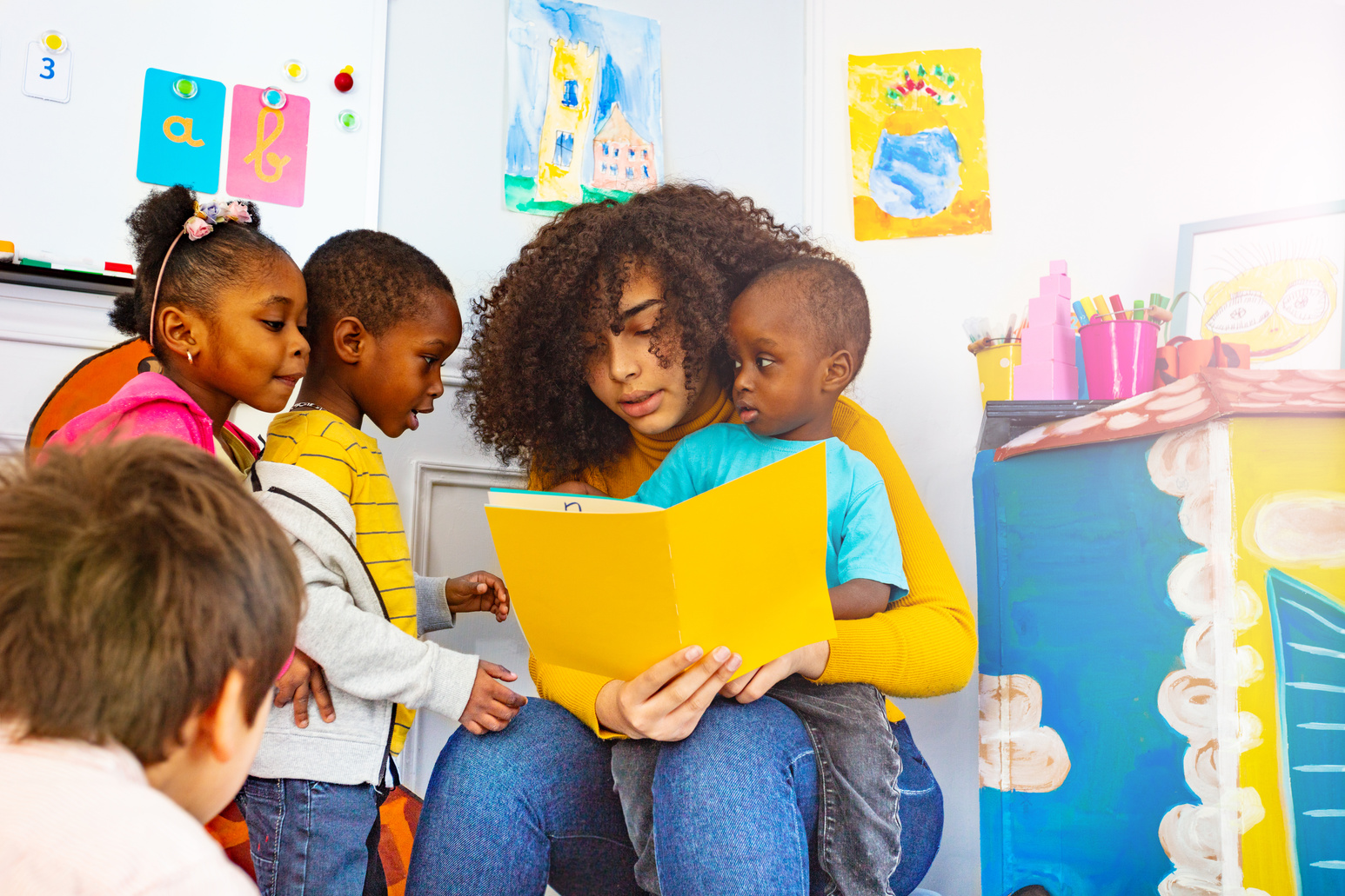 Group of Little Kids Listen to Teacher Read Story