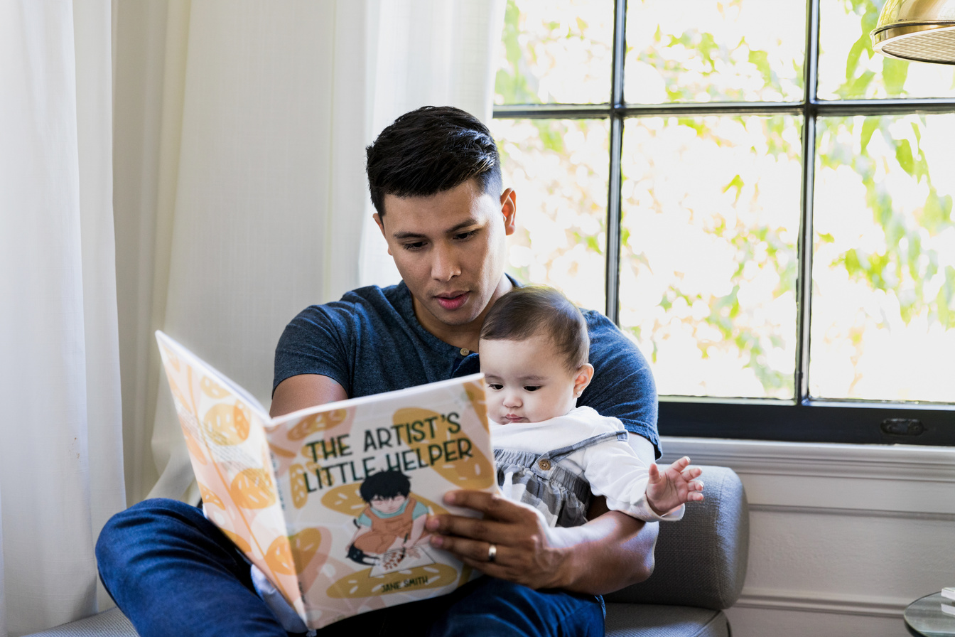 Dad read's storybook to baby daughter
